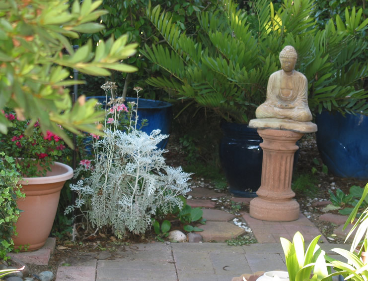 Buddha statue amid flowers in garden at Rad enchanted getaway - San Diego county