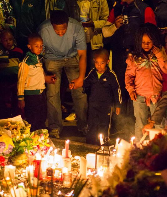 Father and children pay respects outside of Nelson Mandela's home in Johannesburg