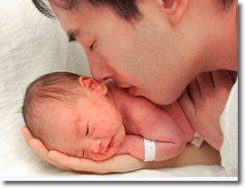 A newborn son in the hand of a new father